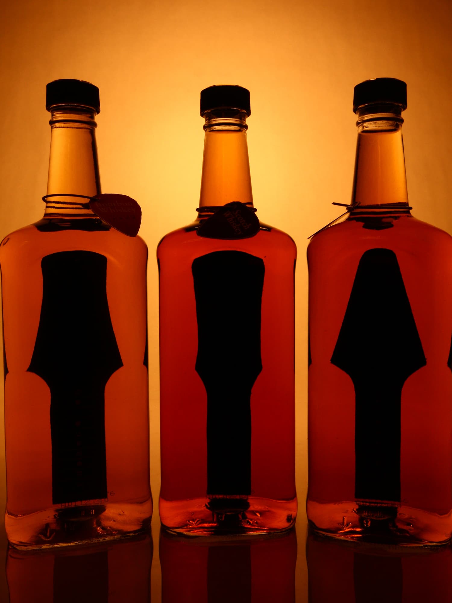 A photo of 3 bottles of whiskey